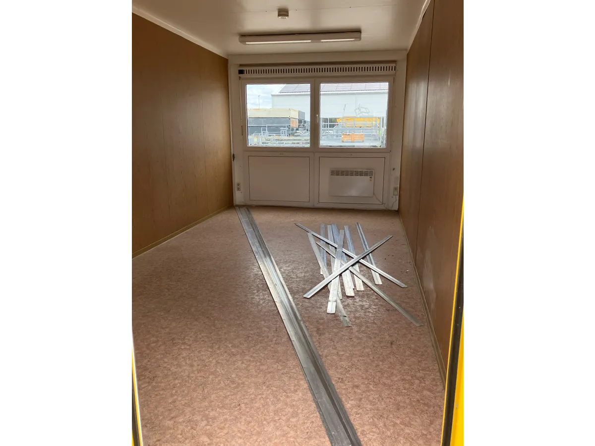 Gebrauchter Bürocontainer Innenansicht mit Fenster und Steinteppichboden