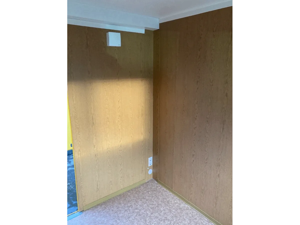 Gebrauchter 10 Fuß Bürocontainer Innenansicht mit Holzwandverkleidung und Steckdosen